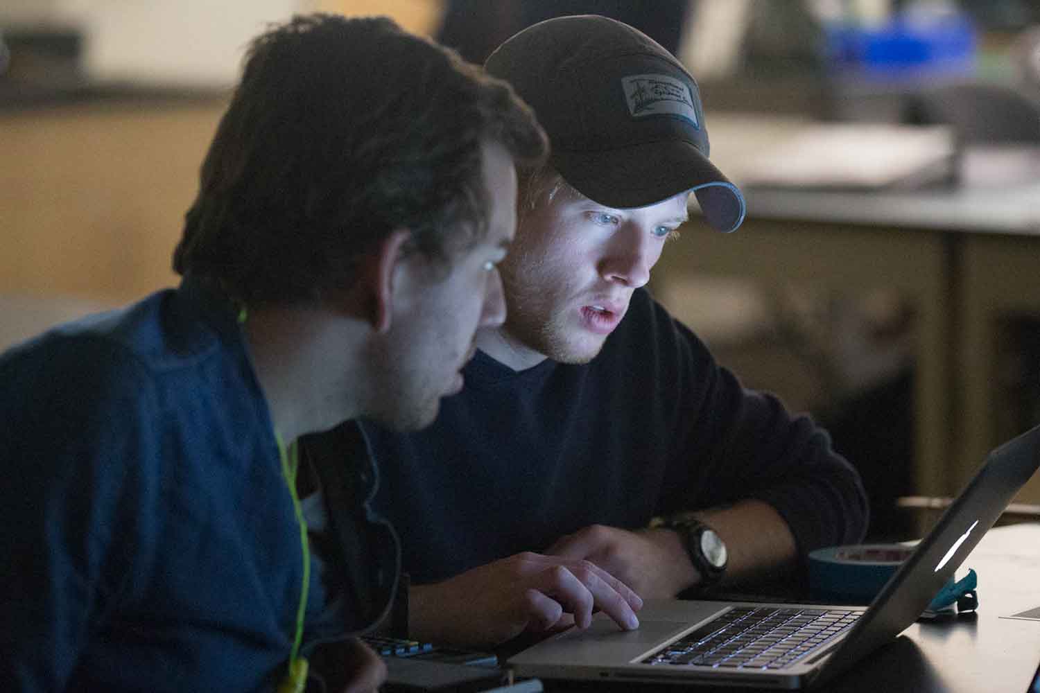 Two students working together on a laptop